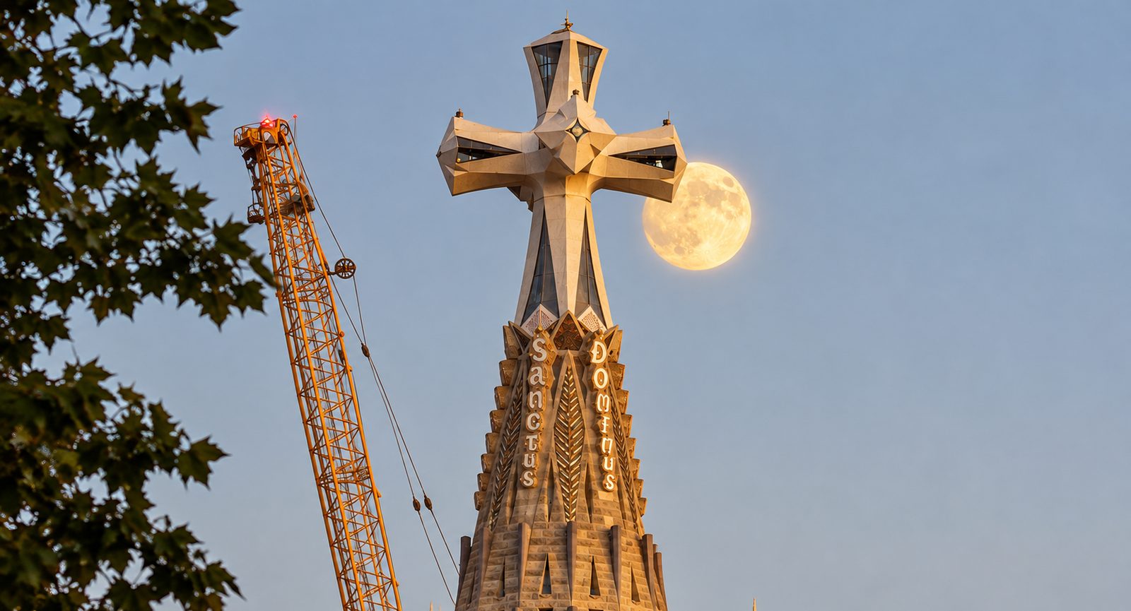 Cross on top of a Sagrada Família tower with the full moon behind it